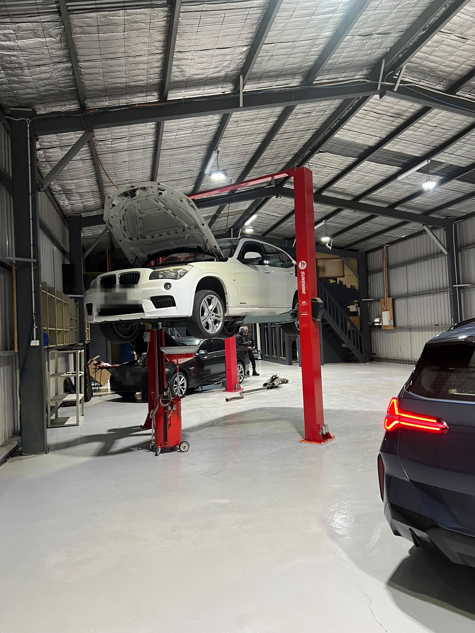 Inside the BIMMER AUTOMOTIVE workshop bay in Craigieburn with a BMW on the hoist
